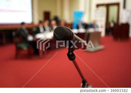 Microphone in focus against blurred audience 16001582