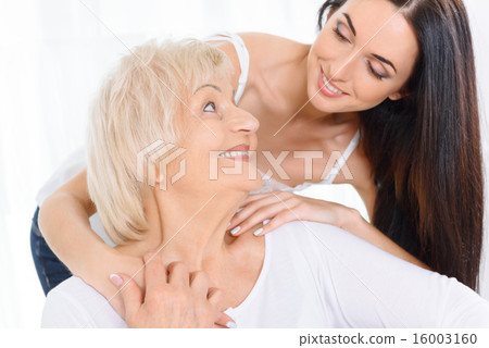 Pretty woman embracing old lady Pretty woman embracing old lady 16003160