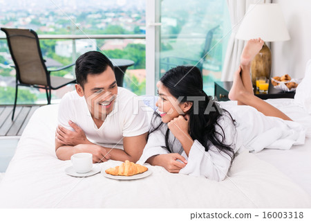 Asian couple having breakfast in bed Asian couple having breakfast in bed 16003318