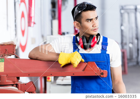 Asian carpenter with electric saw in workshop Asian carpenter with electric saw in workshop 16003335