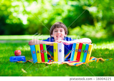 Student boy relaxing in school yard reading books 16004225