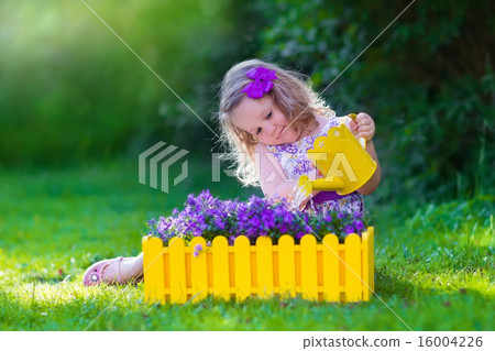 Little girl working in the garden watering flowers 16004226