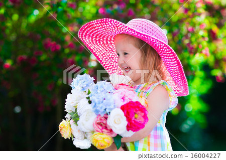Little girl in a hat in blooming summer garden 16004227