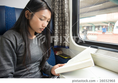 Young woman reading a book on the train 16032968