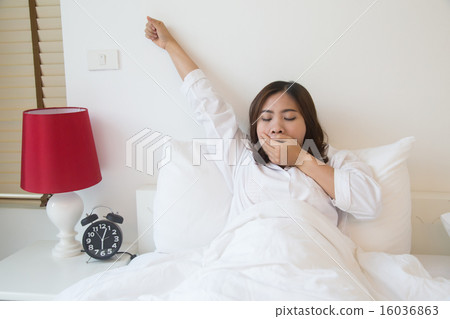 Sleepy asian woman yawning in bed at home Sleepy asian woman yawning in bed at home 16036863