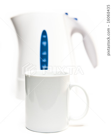 Focus on a tea mug. Electric tea kettle on a white 16068435