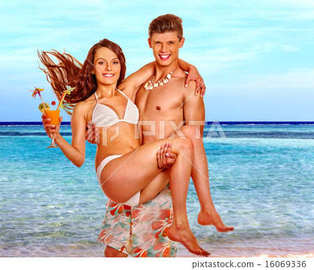Couple with cocktail at Hawaii wreath beach. 16069336