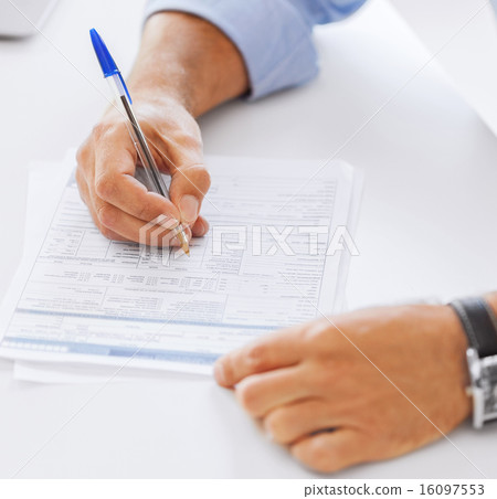 man filling tax form 16097553