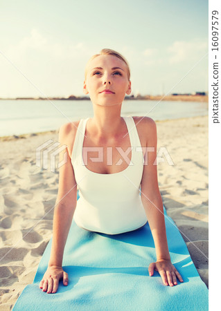 young woman making yoga exercises outdoors 16097579