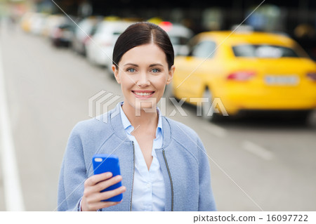smiling woman with smartphone over taxi in city smiling woman with smartphone over taxi in city 16097722