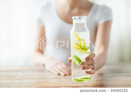 close up of woman with fruit water in glass bottle close up of woman with fruit water in glass bottle 16098105