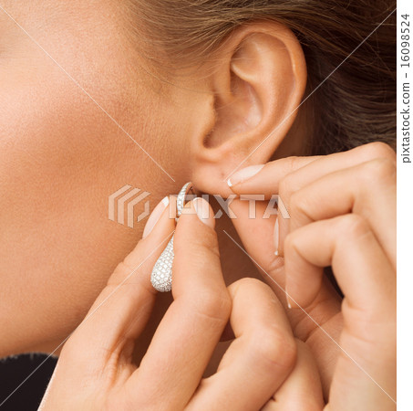 woman wearing shiny diamond earrings woman wearing shiny diamond earrings 16098524