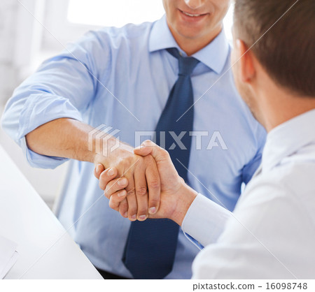 businessmen shaking hands in office 16098748