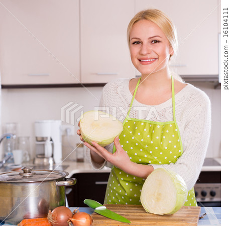 Happy woman in apron posing with cabbage Happy woman in apron posing with cabbage 16104111