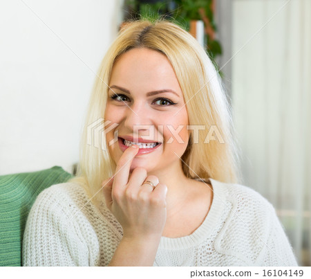 Curious blonde sitting on sofa 16104149