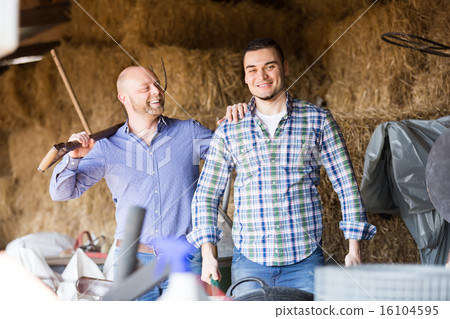 Two farmers working in barn 16104595