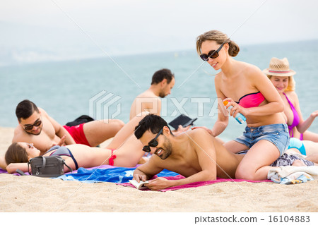 Vacationers sunbathing near ocean Vacationers sunbathing near ocean 16104883