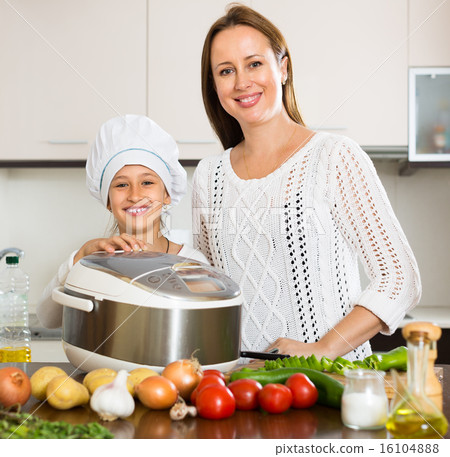 mother and daughter using multicooker 16104888