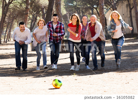 Positive adults chasing ball outdoors 16105082