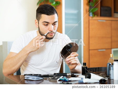 guy shaving by electric shaver 16105189