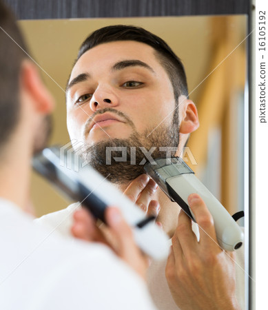 Looking at mirror and shaving face 16105192