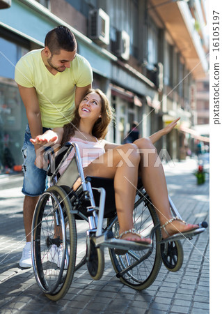 Husband taking spouse on wheelchair 16105197