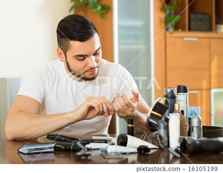 Man doing manicure at home 16105199