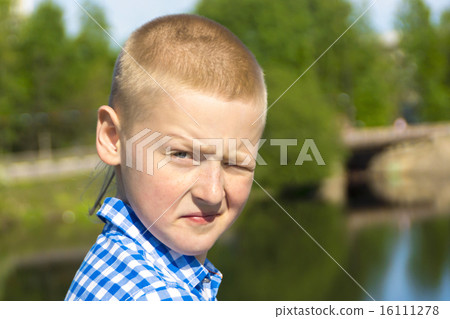 Ten year boy squints in the sun 16111278