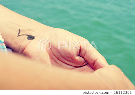 man with a musical note tattooed in his wrist 16112391