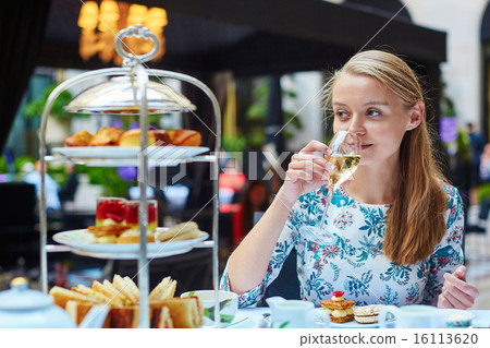 Beautiful young woman enjoying afternoon tea Beautiful young woman enjoying afternoon tea 16113620