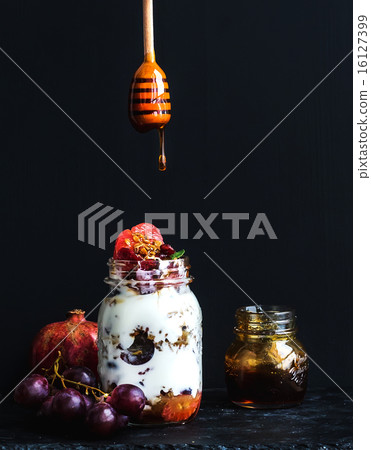 Yogurt and oat granola with grapes, pomegranate, grapefruit in tall glass jar Yogurt and oat granola with grapes, pomegranate, grapefruit in tall glass jar 16127399