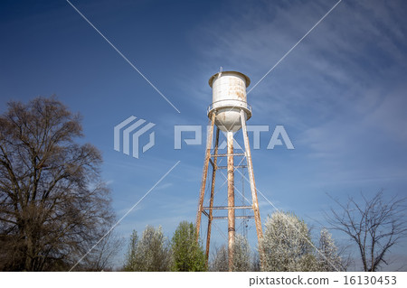 Tall  water tower with cloudy blue sky background 16130453