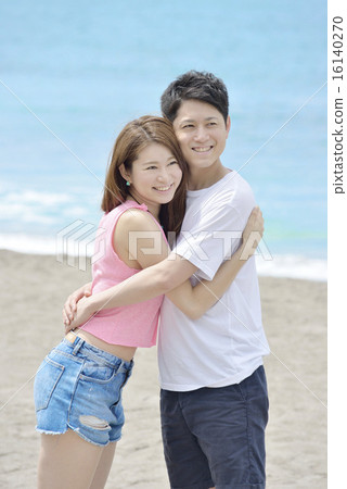 A couple embracing at the sandy beach A couple embracing at the sandy beach 16140270