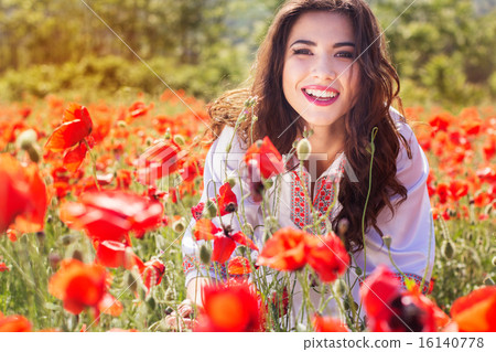 Beautiful young woman is posing near roses in a garden Beautiful young woman is posing near roses in a garden 16140778