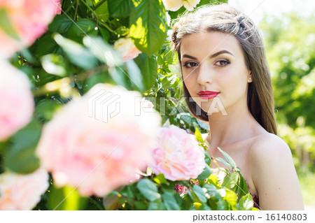 Closeup portrait of pretty girl near pink roses Closeup portrait of pretty girl near pink roses 16140803
