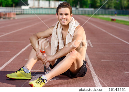 Smiling sportsman sitting and having rest Smiling sportsman sitting and having rest 16143261
