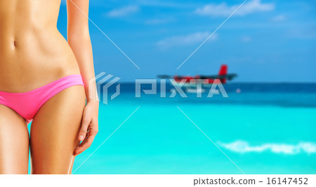 Woman on beach with seaplane at Maldives 16147452
