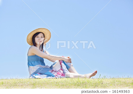 婦女坐小山在藍天下和放鬆 婦女坐小山在藍天下和放鬆 16149363