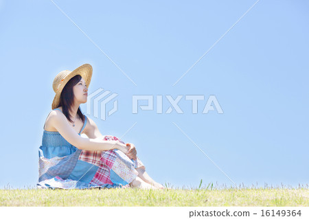婦女坐小山在藍天下和放鬆 16149364