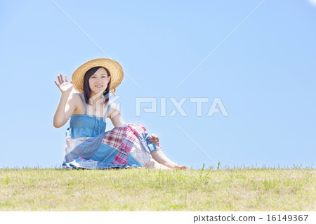 婦女坐小山在藍天下和放鬆 婦女坐小山在藍天下和放鬆 16149367
