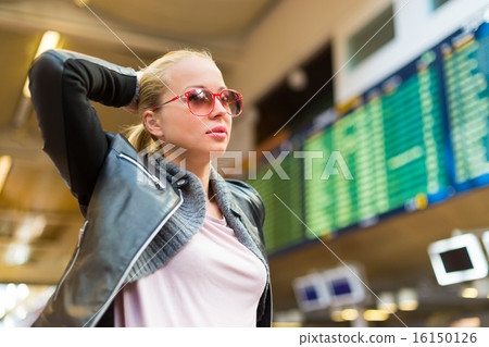 Female traveller checking flight departures board. 16150126