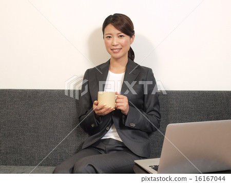 有一個咖啡杯的一名婦女在辦公室 有一個咖啡杯的一名婦女在辦公室 16167044