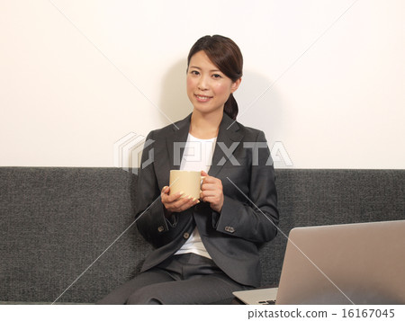 A woman with a coffee cup in the office A woman with a coffee cup in the office 16167045