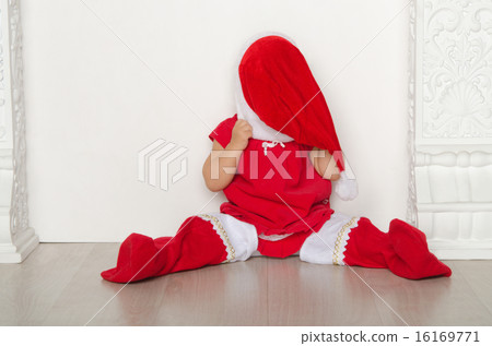 girl in costume of Santa closes face sitting on floor girl in costume of Santa closes face sitting on floor 16169771