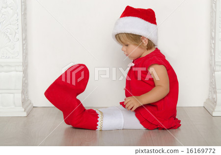 girl in costume of Santa looks at his feet girl in costume of Santa looks at his feet 16169772