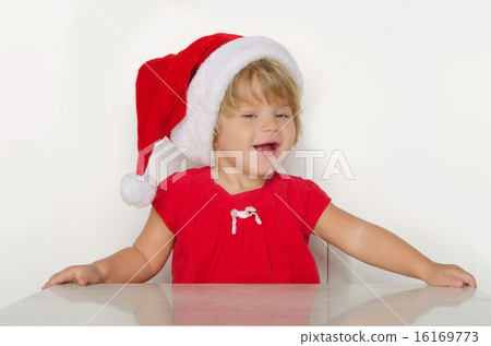 girl in costume of Santa Claus at table and smiling girl in costume of Santa Claus at table and smiling 16169773