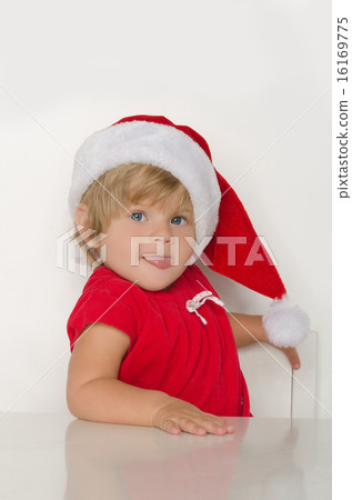 Child dressed as Santa Claus at table Child dressed as Santa Claus at table 16169775