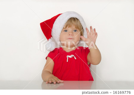 happy little girl in costume of Santa at table 16169776