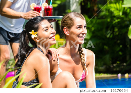 Women in vacation at hotel pool with cocktails 16170664