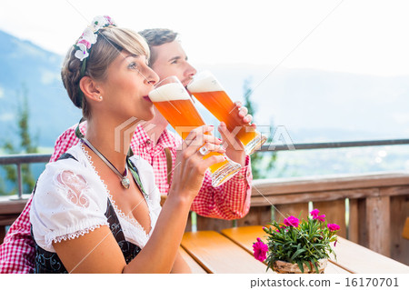 Couple on mountain hut drinking wheat beer 16170701